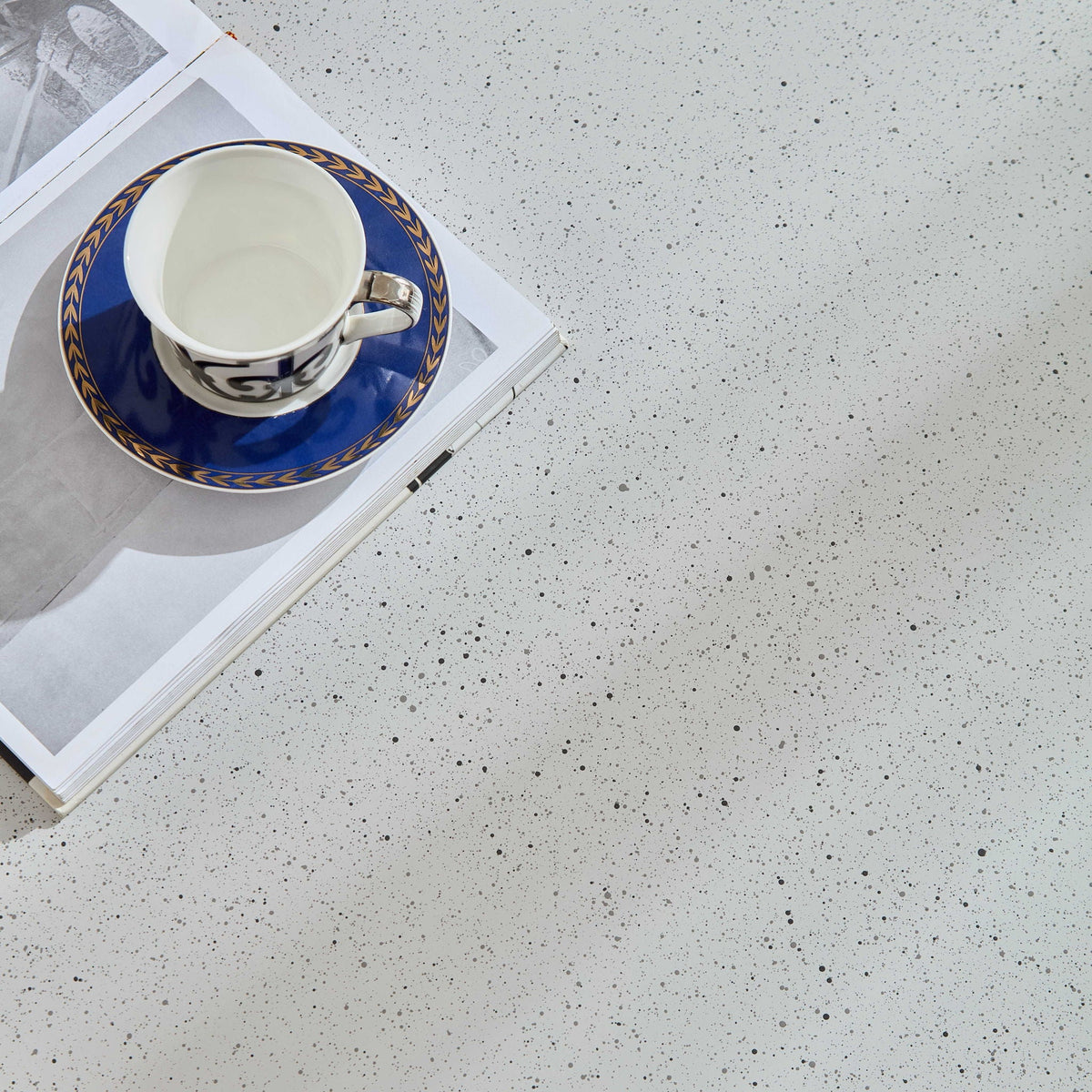 End table decor: blue porcelain teacup on blue saucer with gold laurel border on magazine on Tampa Home & Garden Store