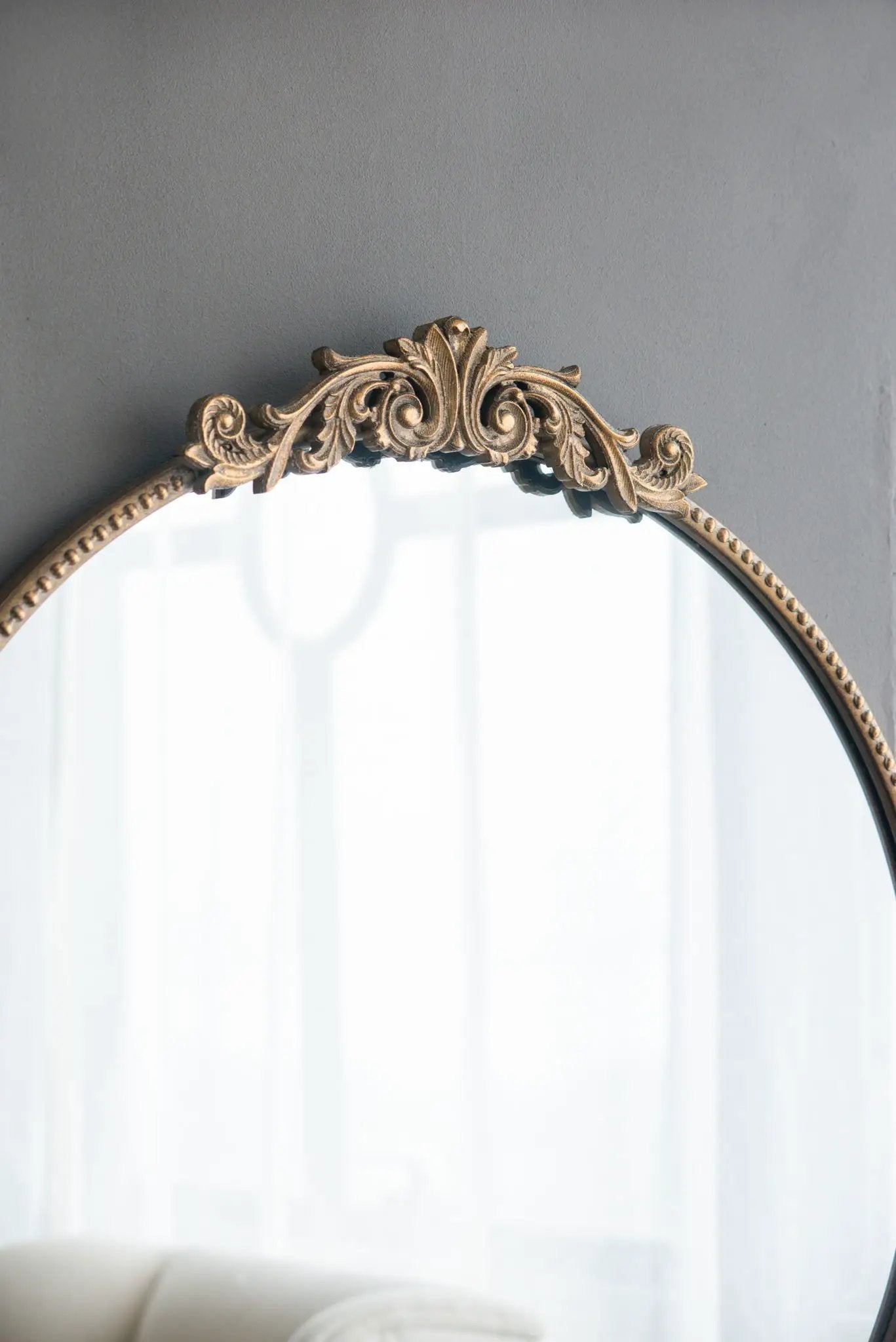 Wall mirror with a gold-toned Baroque-inspired carved frame featuring scrolls and leaf motifs; beaded edge on Tampa Home & Garden Store