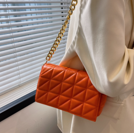 Orange quilted shoulder bag with thick gold chain strap on Tampa Home & Garden Store