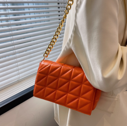 Orange quilted shoulder bag with thick gold chain strap on Tampa Home & Garden Store