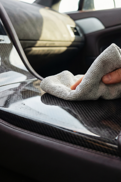 BLACKLINE® CARBON CLOTH polishing cloth used on a glossy carbon fiber car panel inside a vehicle on Tampa Home & Garden Store