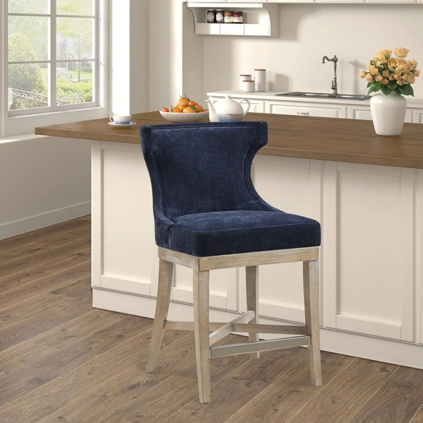 Counter-height Carson swivel stool in blue velvet with light wood legs at kitchen island on Tampa Home & Garden Store