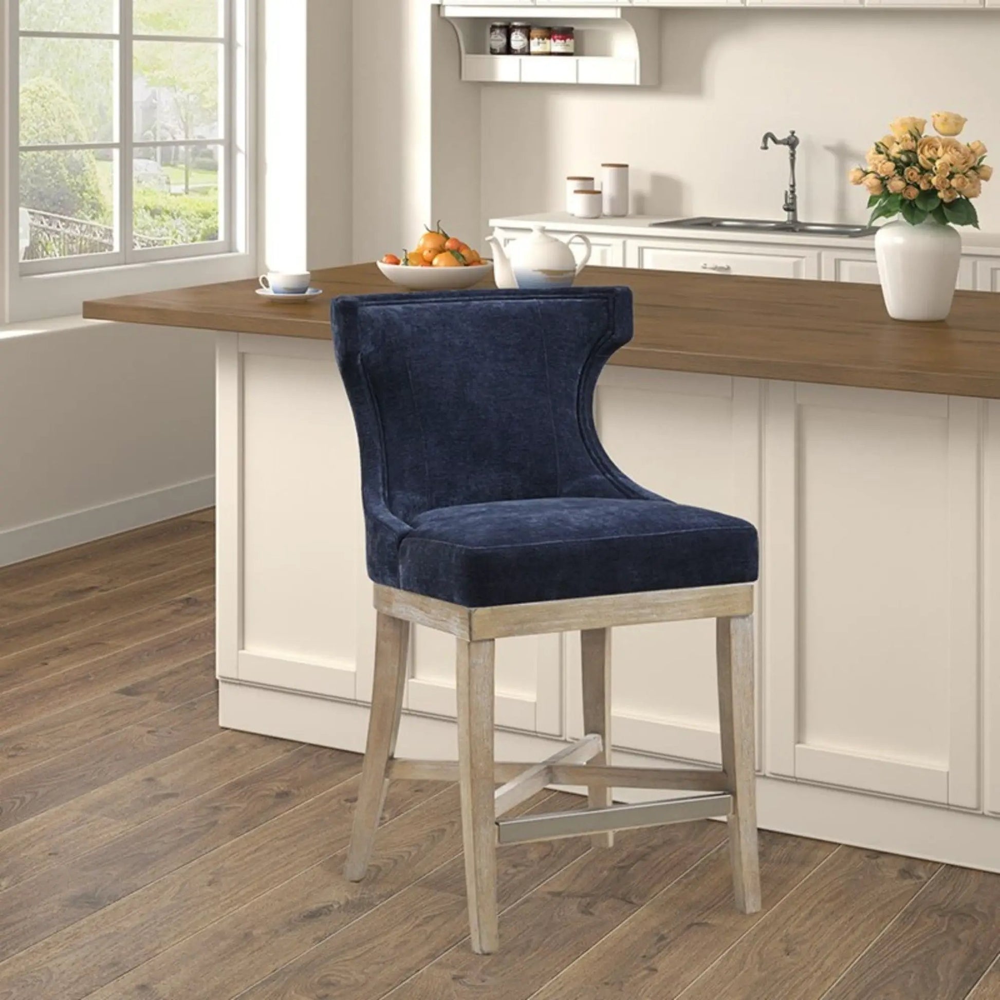 Counter-height Carson swivel stool in blue velvet with light wood legs at kitchen island on Tampa Home & Garden Store