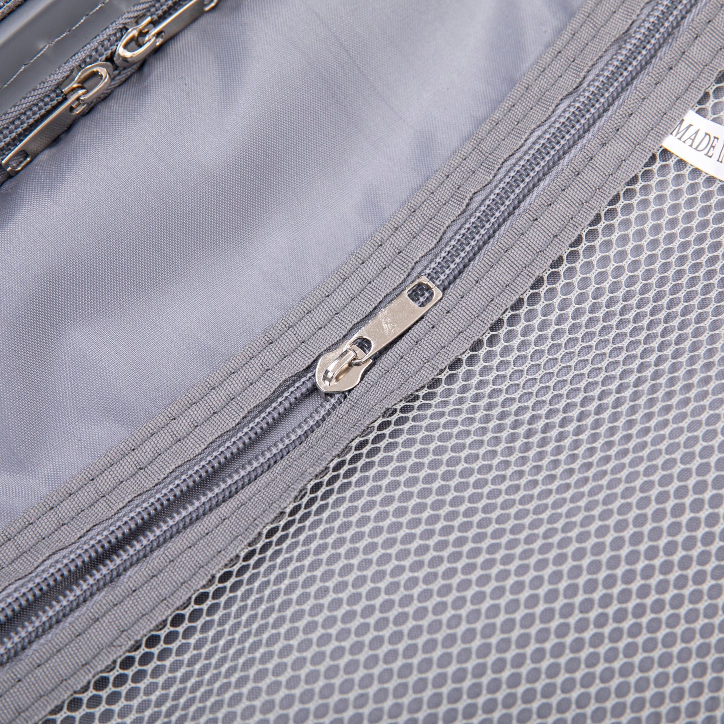 Luggage interior close-up in light gray with mesh pocket and metal zippers on Tampa Home & Garden Store