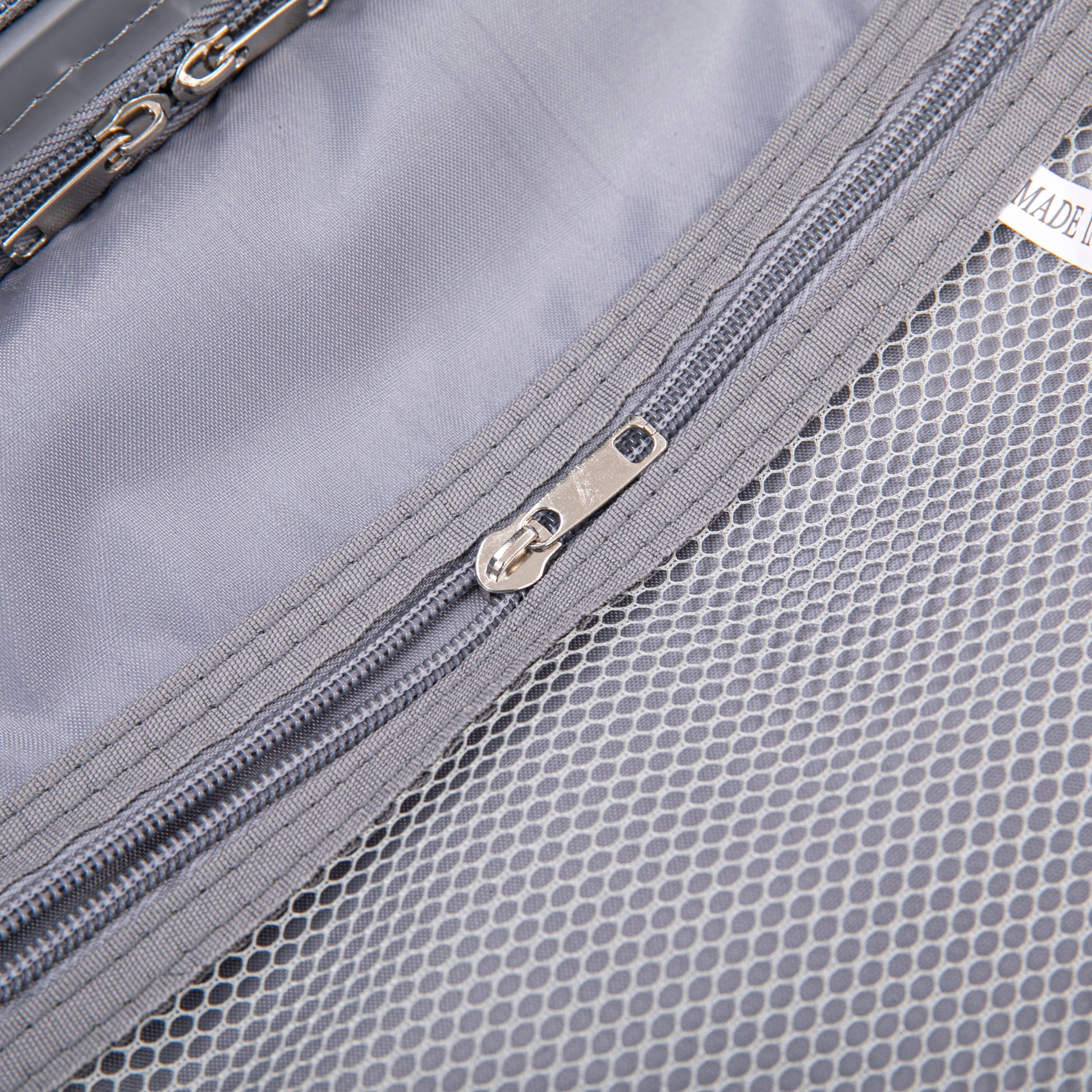 Luggage interior close-up in light gray with mesh pocket and metal zippers on Tampa Home & Garden Store