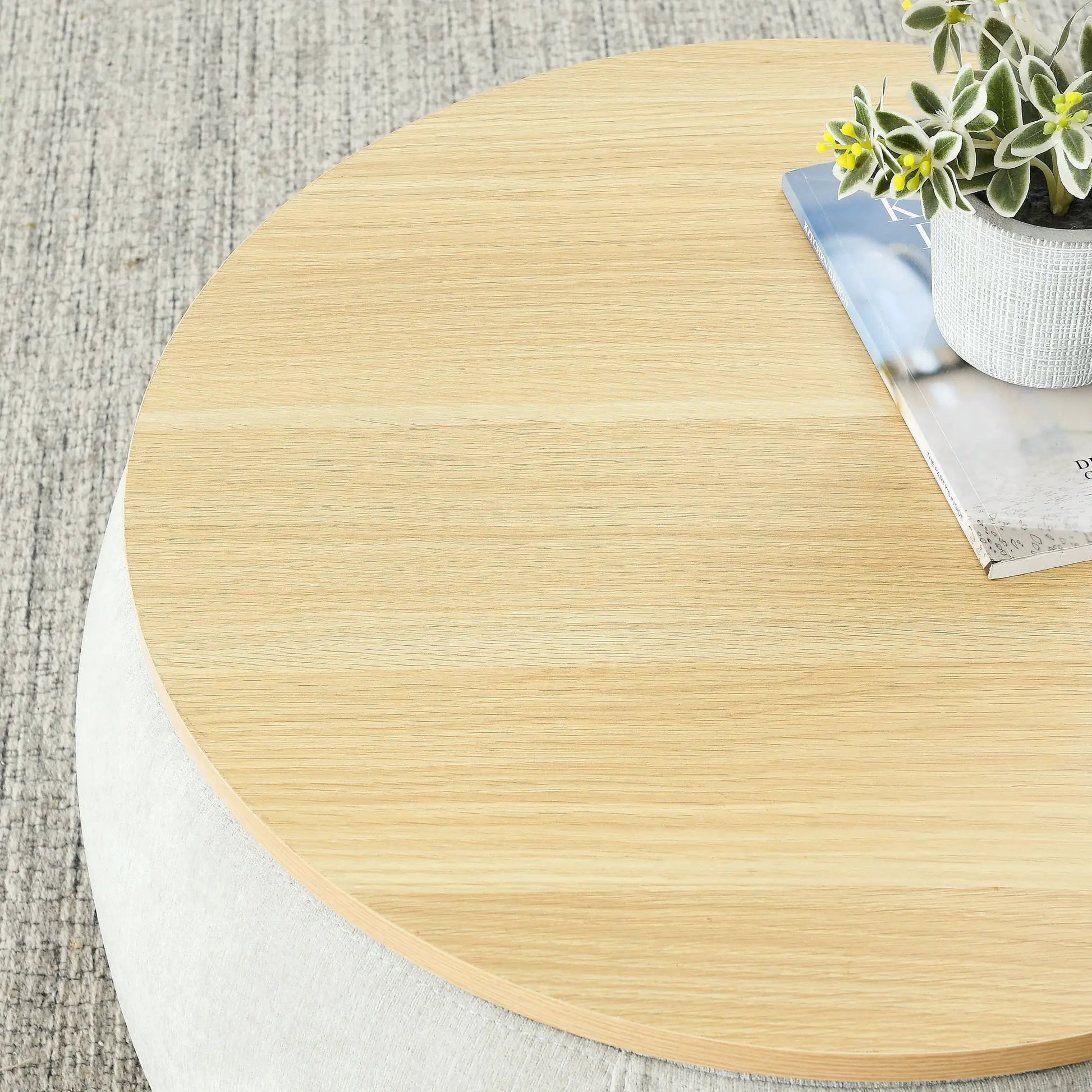 Round light oak end table with a white textured planter and a magazine on Tampa Home & Garden Store