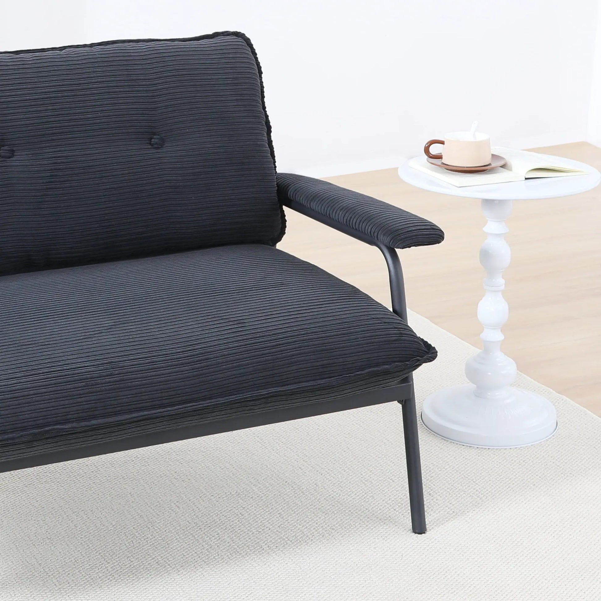 Modern metal-frame sofa with sponge cushions in black beside a white round side table on Tampa Home & Garden Store