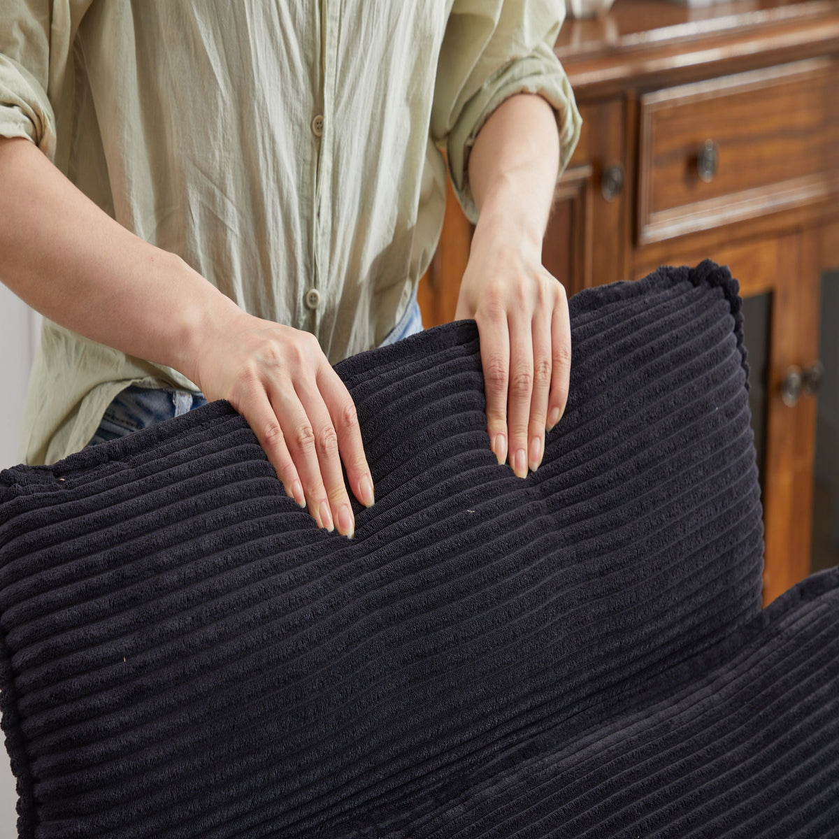 Navy knit throw blanket by HouseOfZazla with ribbed texture being folded near a wooden dresser on Tampa Home & Garden Store