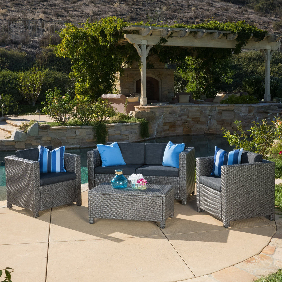 Puerta 4-Piece Outdoor Furniture Set dark gray wicker seating with blue cushions around a coffee table under a vine-draped pergola on Tampa Home & Garden Store