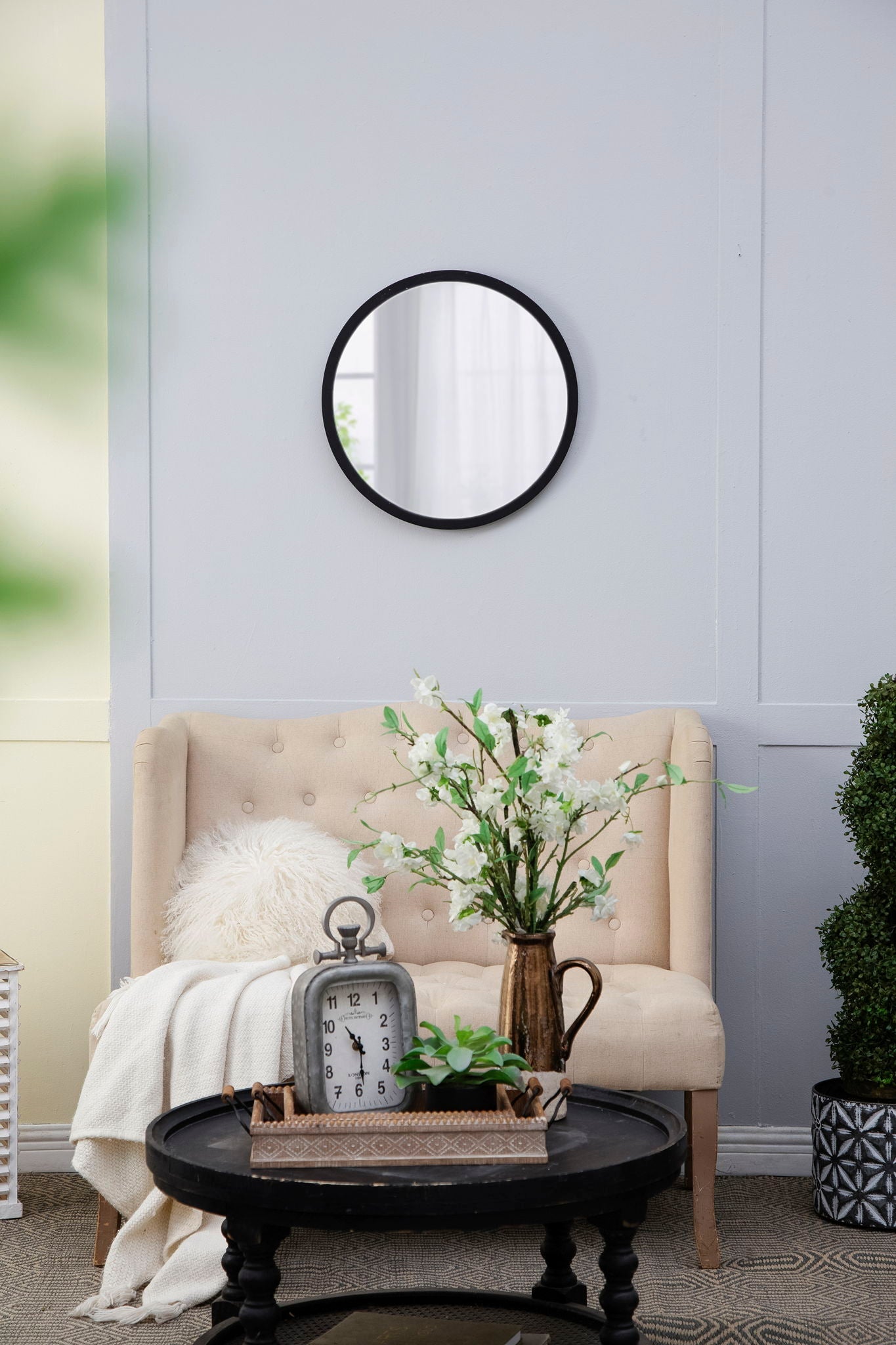 Circle wall mirror with wooden frame on pale blue paneled living room wall on Tampa Home & Garden Store