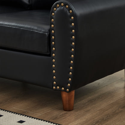 Black faux-leather loveseat arm close-up with brass nailhead trim and a dark wood leg on Tampa Home & Garden Store
