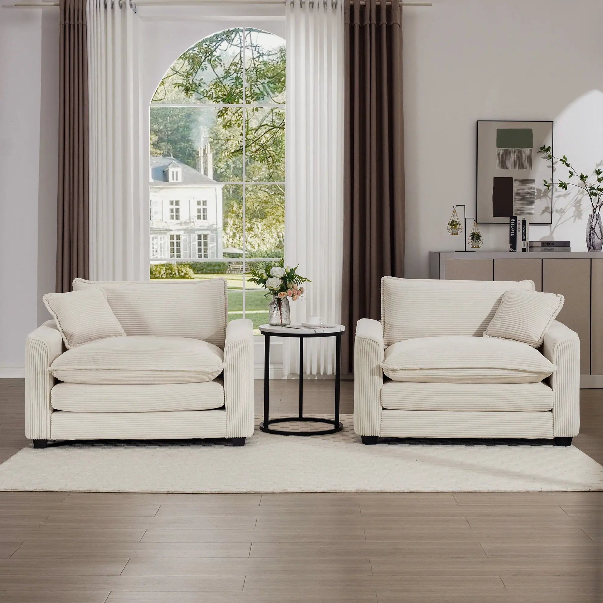 Modern Classic fabric armchairs pair in cream with pillows by an arched window on Tampa Home & Garden Store