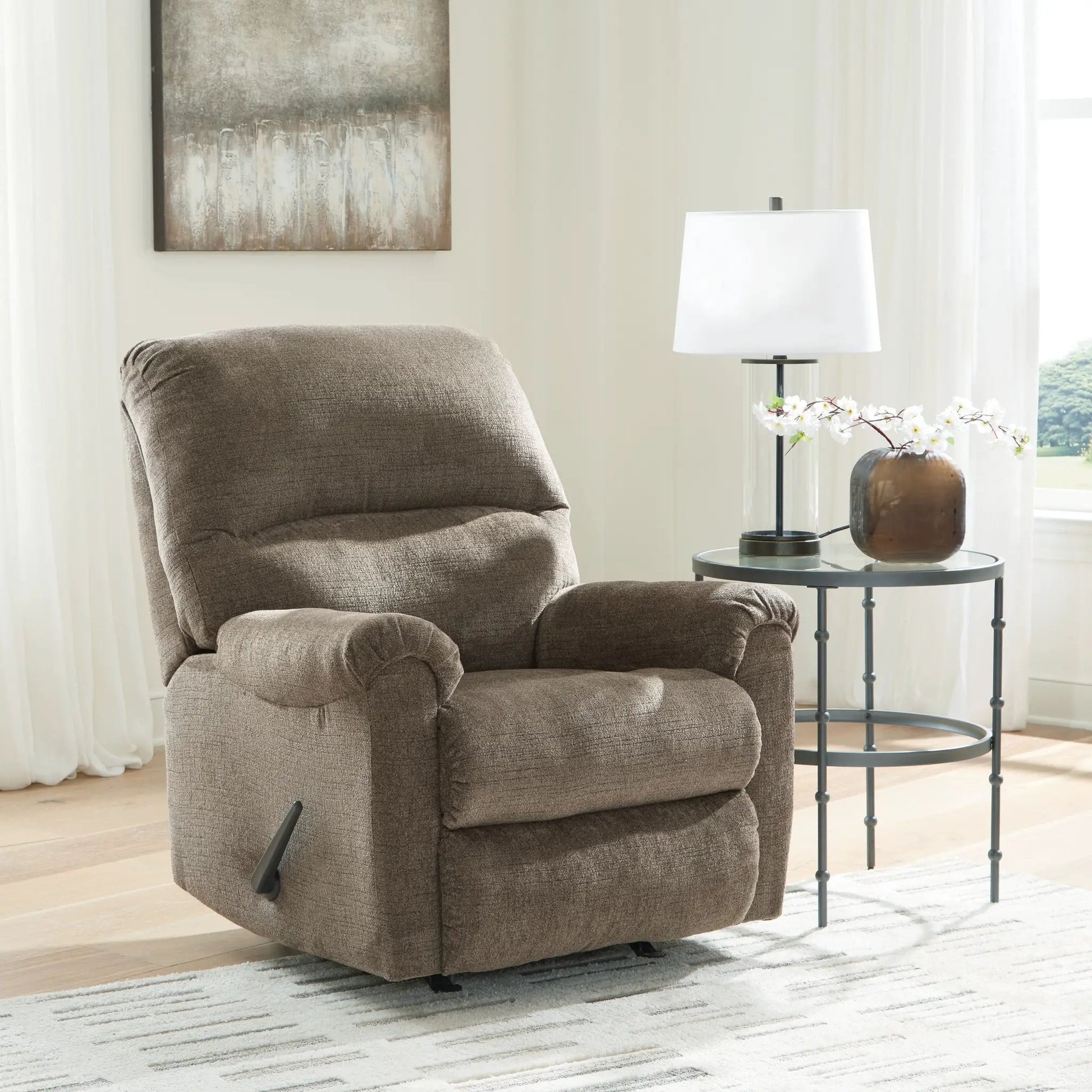 Stonemeade rocker recliner in brown fabric beside a round glass-top side table with a white lamp on Tampa Home & Garden Store