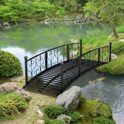 Outsunny 7' metal arch garden bridge with safety siderails over a lakeside garden on Tampa Home & Garden Store