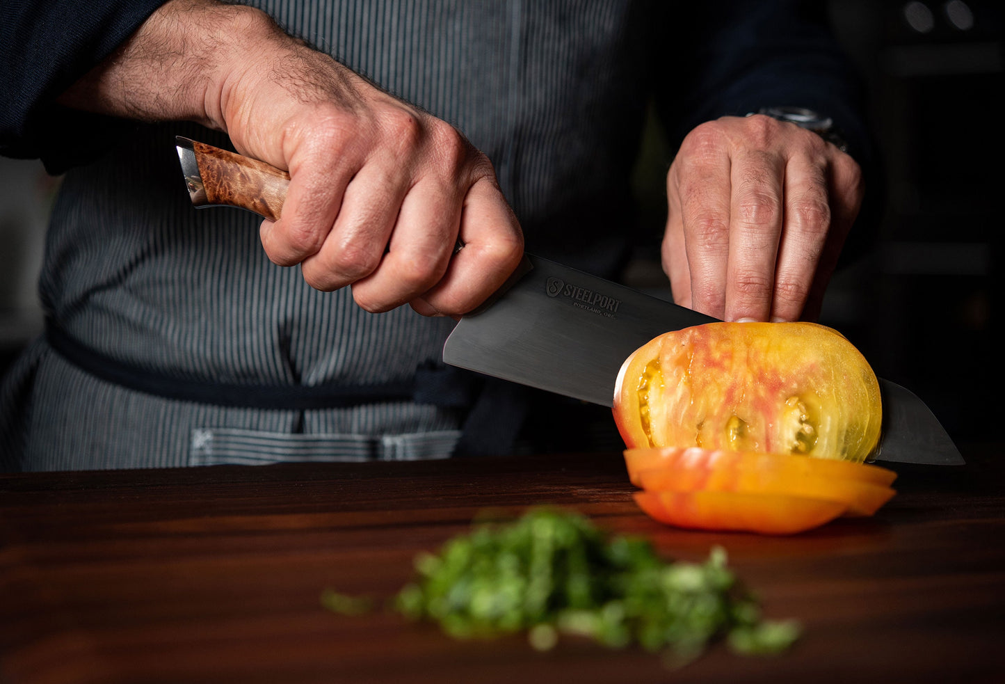 8-inch chef knife by STEELPORT Knife Co. with marbled wooden handle slicing orange tomato on Tampa Home & Garden Store