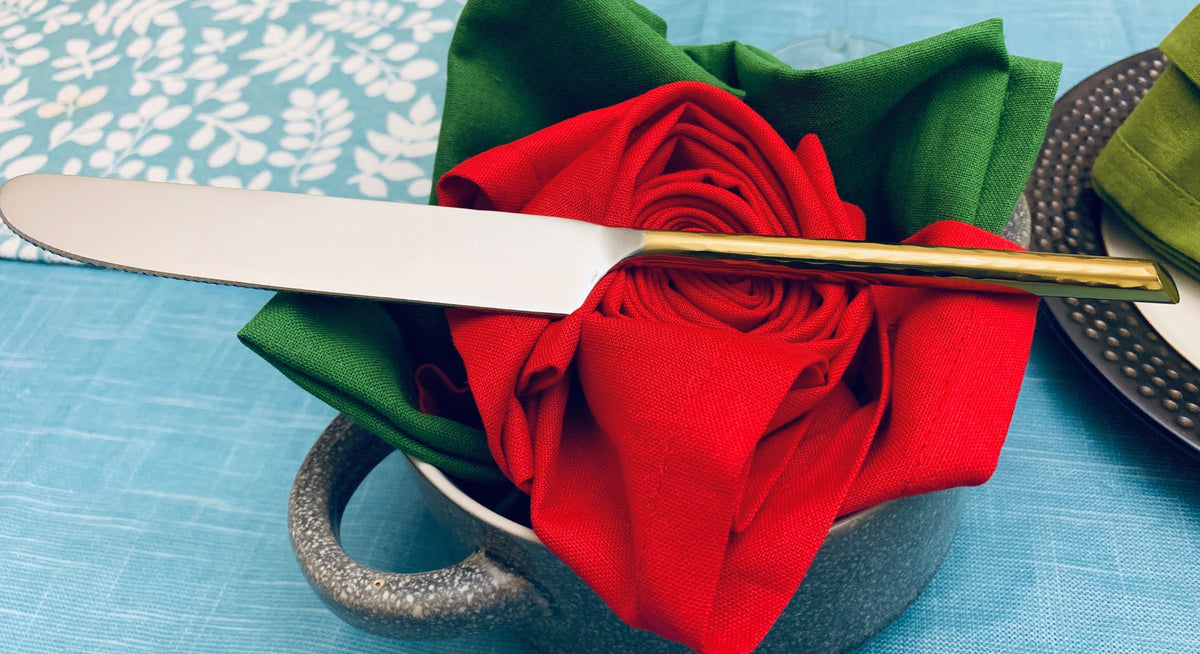 Vibhsa gold dinner knife with silver blade resting on red napkin from a table knives set on Tampa Home & Garden Store