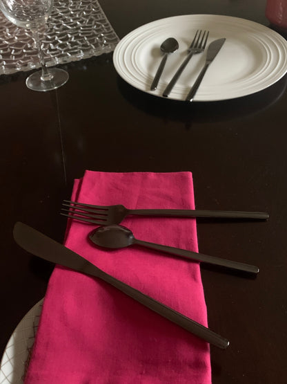 Vibhsa 36-piece black stainless steel flatware set with forks, knives and spoons on pink napkin on Tampa Home & Garden Store