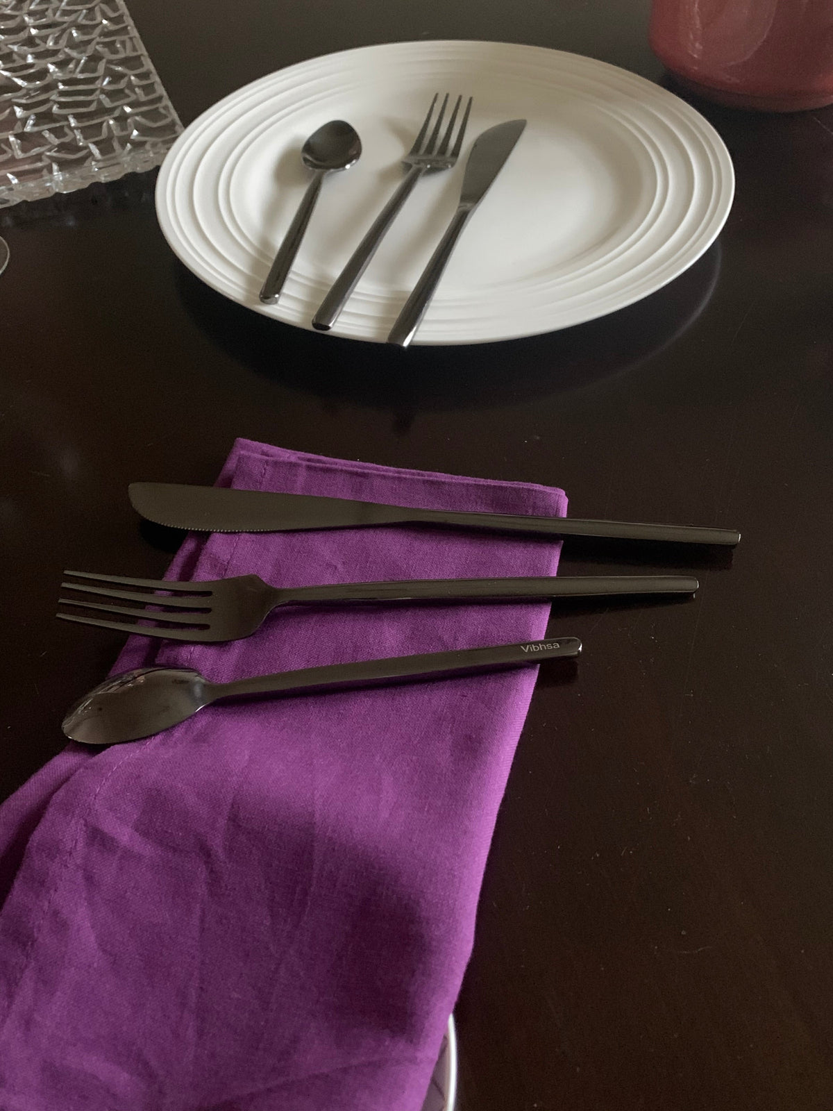 Vibhsa 18-piece stainless steel flatware set with spoon, fork and knife on white plates on Tampa Home & Garden Store