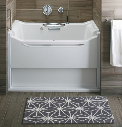 Vibhsa bath rug grey ivory geometric pattern on tiled bathroom floor in front of a white bathtub on Tampa Home & Garden Store