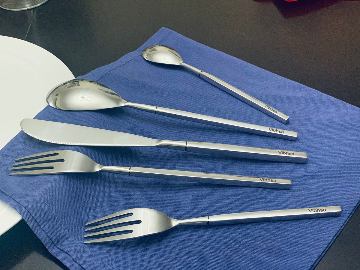 Vibhsa 20-piece stainless steel flatware set with forks, knives and spoons on blue napkin on Tampa Home & Garden Store