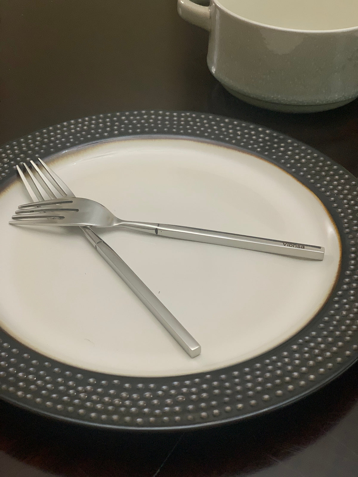 Vibhsa 20-piece stainless steel flatware on a white plate with a dotted gray rim on Tampa Home & Garden Store