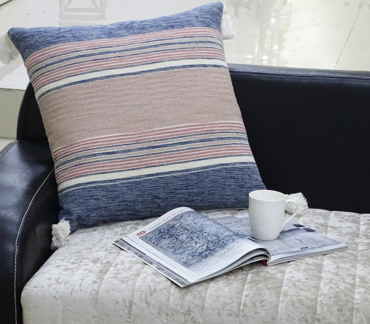 22x22 striped throw pillow with tassels in blue, pink, cream on a black sofa on Tampa Home & Garden Store