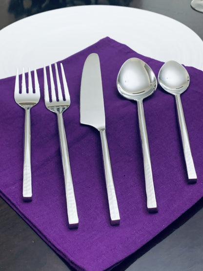 Vibhsa flatware set service for 4 in silver, with forks, knives and spoons on a purple napkin on Tampa Home & Garden Store