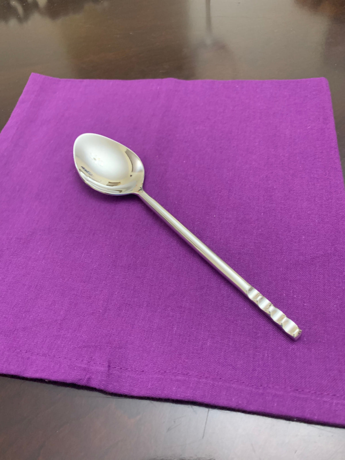 Vibhsa flatware spoon, silver stainless steel with ribbed handle on purple napkin on Tampa Home & Garden Store