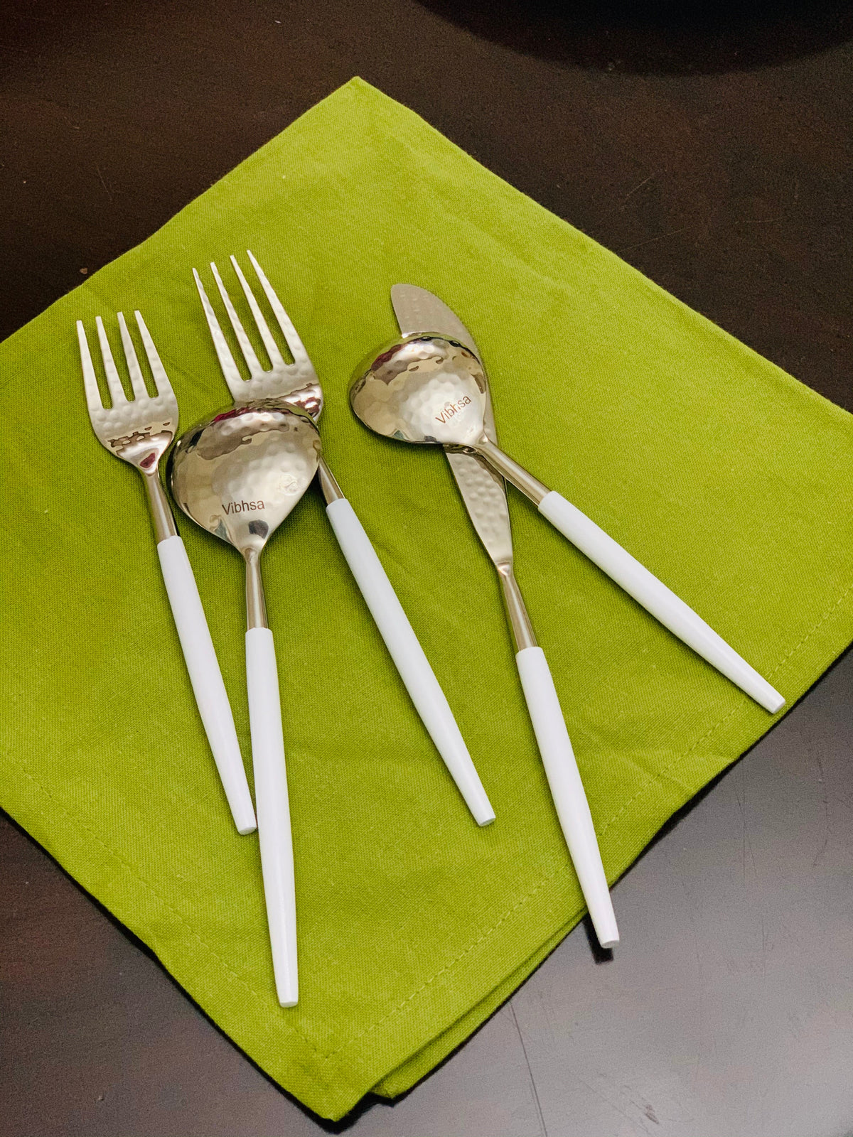 Vibhsa white & silver flatware set of 20 with white handles on green mat on Tampa Home & Garden Store