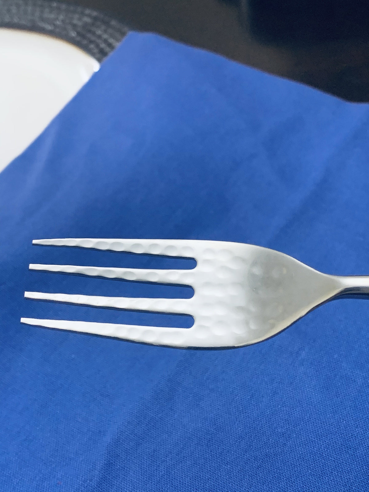 Vibhsa dinner forks with hammered mouth, white finish, two shown on blue background on Tampa Home & Garden Store