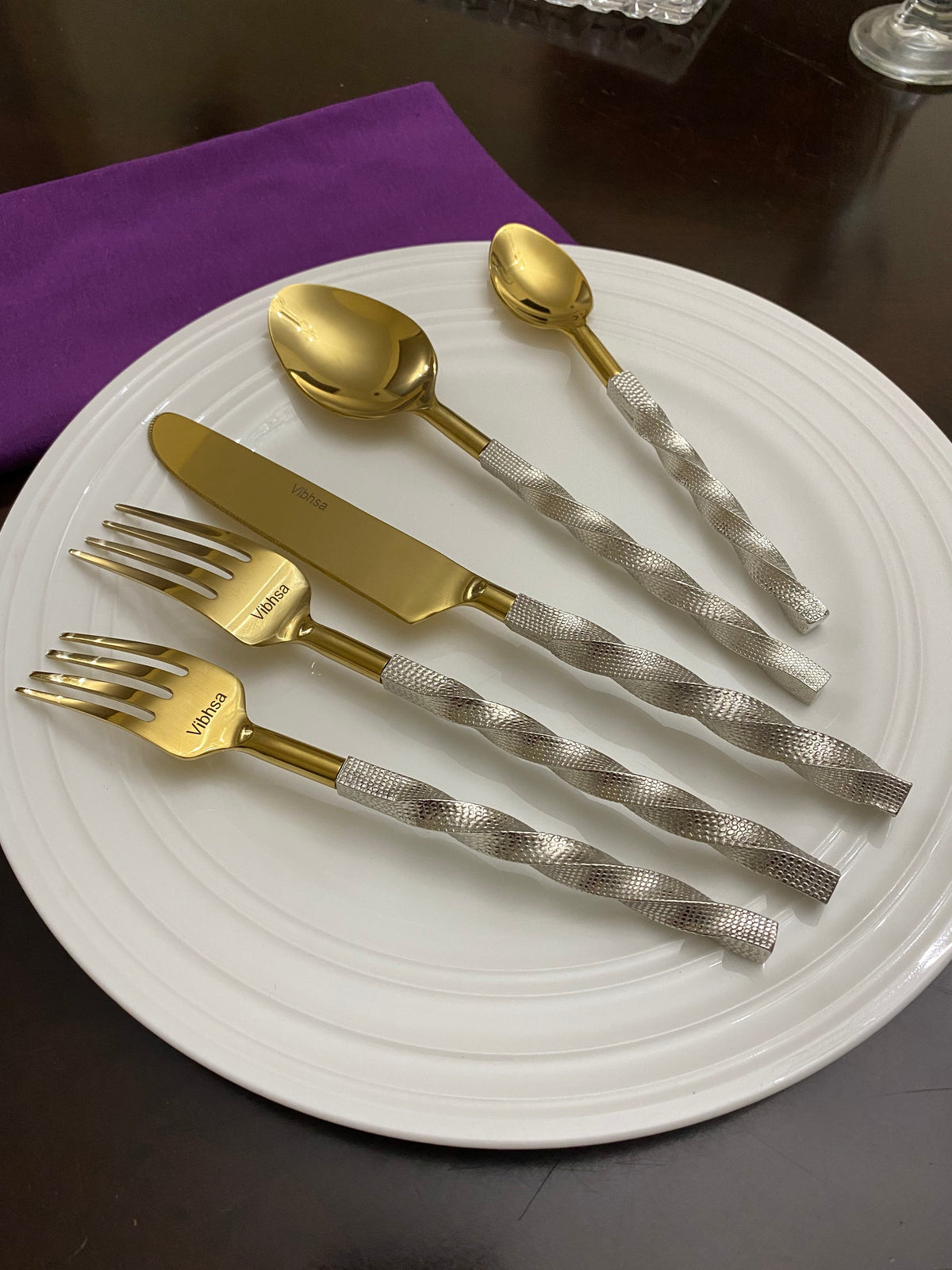 Flatware set 20 pc Vibhsa gold stainless steel with textured handles on white plate on Tampa Home & Garden Store