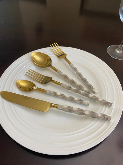 Vibhsa gold stainless steel flatware set 20pc with gold spoons and forks and silver textured handles on a white plate on Tampa Home & Garden Store