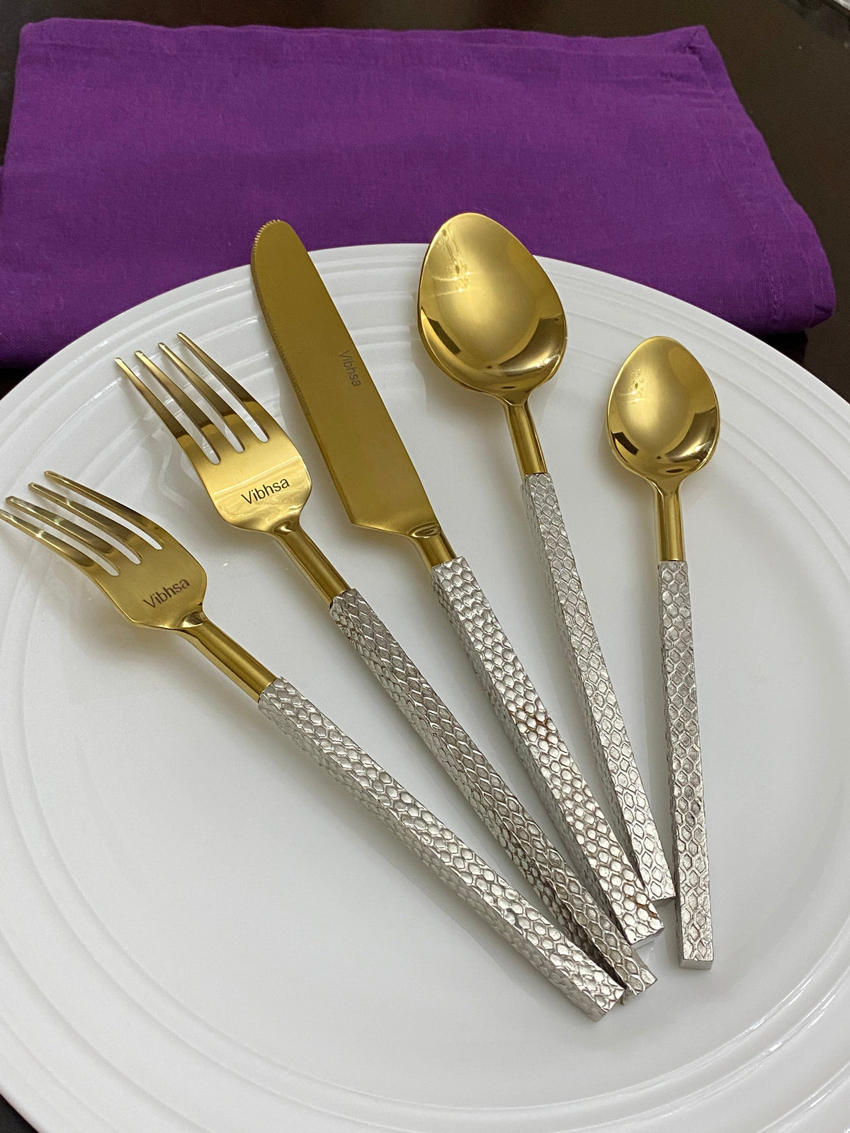 Vibhsa Designer gold stainless steel flatware set 20pc with textured silver handles on a white plate on Tampa Home & Garden Store