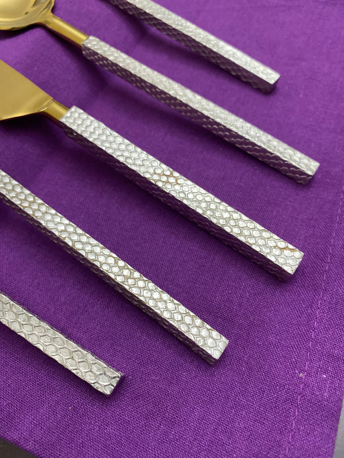 Vibhsa flatware 20pc set with gold-toned stainless steel and textured silver handles on purple background on Tampa Home & Garden Store