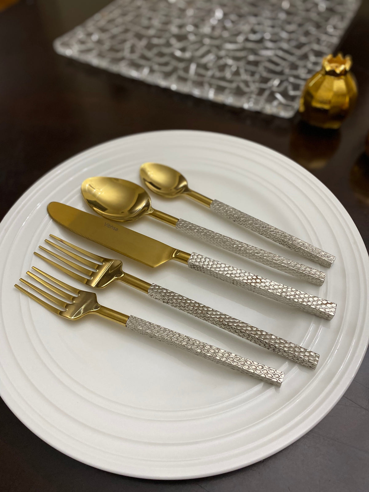 Vibhsa 20pc gold stainless steel flatware set with textured silver handles on a white plate on Tampa Home & Garden Store