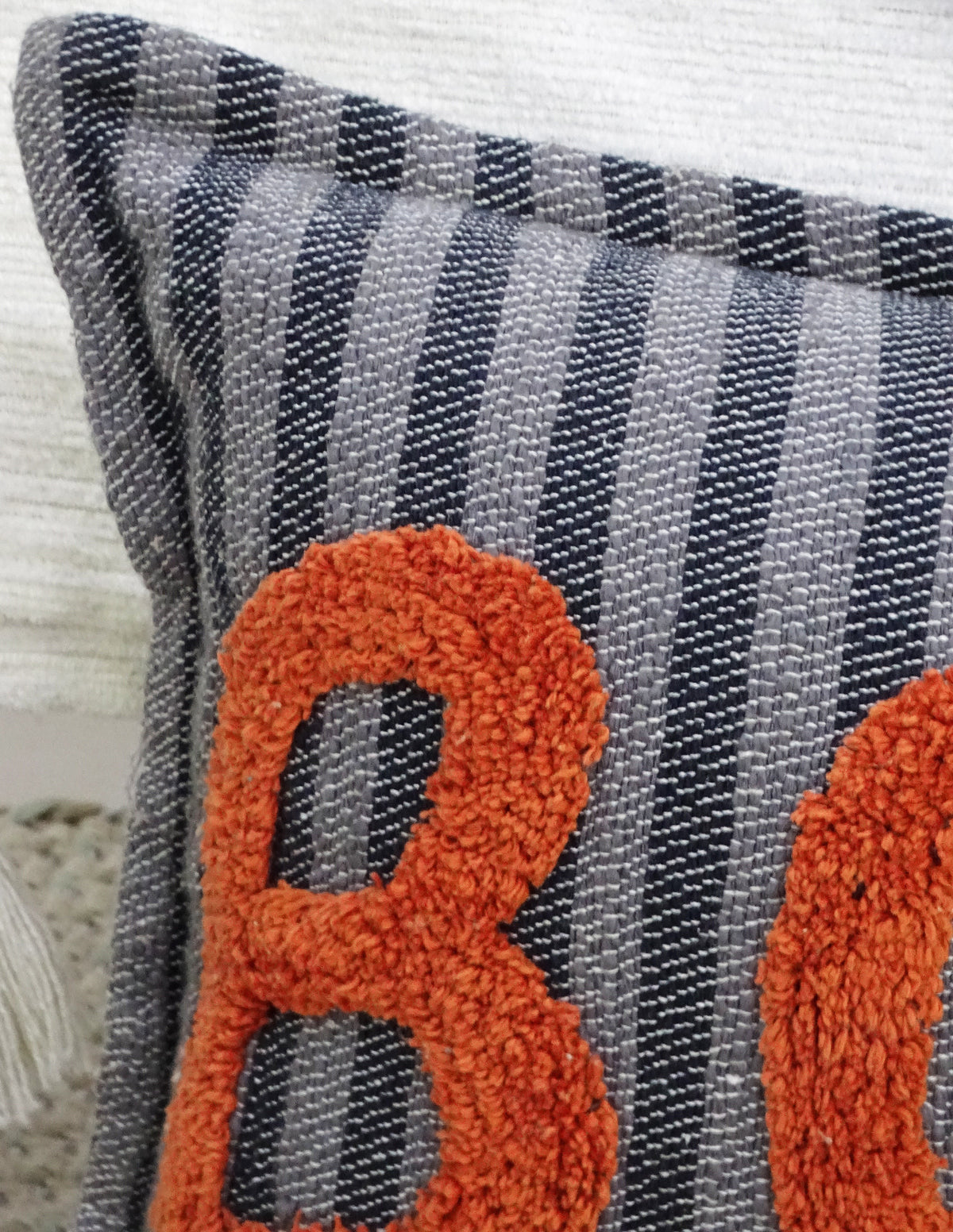 Vibhsa throw pillow with orange boucle BOO letters on gray plaid fabric on Tampa Home & Garden Store