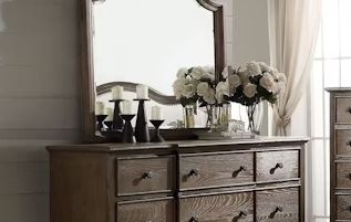 Weathered oak beveled-edge mirror above a rustic oak dresser with flowers and candles on Tampa Home & Garden Store