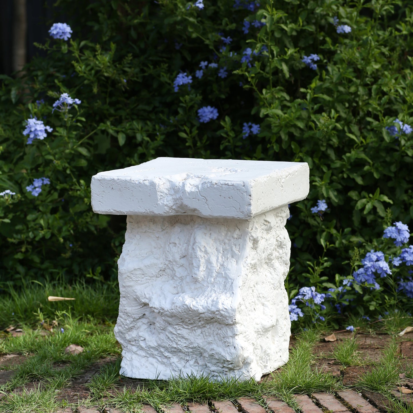 Talia Outdoor MGO Side Table white textured stone finish in garden setting on Tampa Home & Garden Store