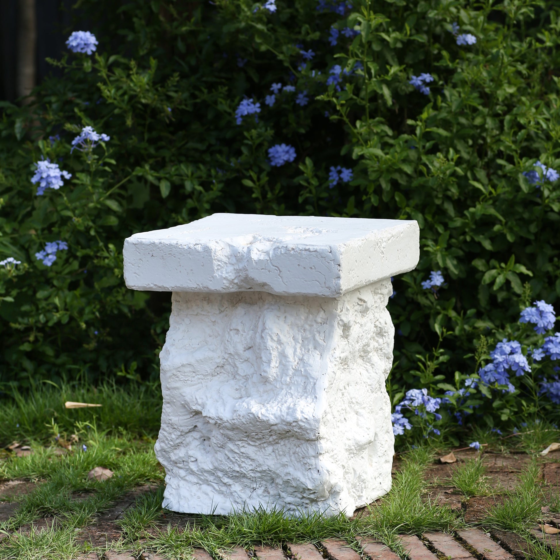Talia Outdoor MGO Side Table white textured stone finish in garden setting on Tampa Home & Garden Store