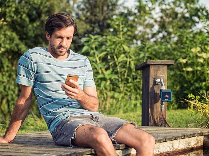 Water Control Bluetooth watering controller Gardena on deck beside a man with smartphone on Tampa Home & Garden Store