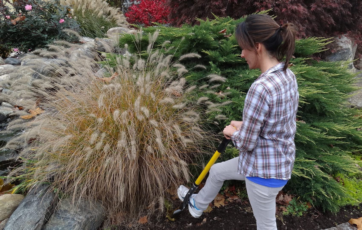 Spear Head Spade 40 in D-grip garden tool with yellow shaft held by a person in plaid in a yard on Tampa Home & Garden Store