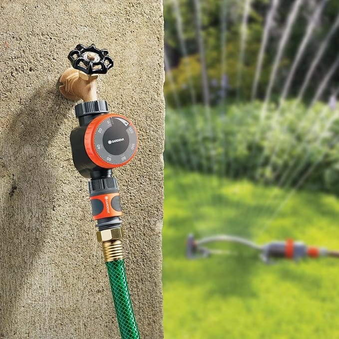 Gardena mechanical water timer with flow control, black body and red dial, hose attached to wall on Tampa Home & Garden Store