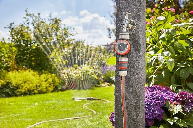Gardena mechanical water timer with flow control and red dial mounted on a tree post in sun on Tampa Home & Garden Store
