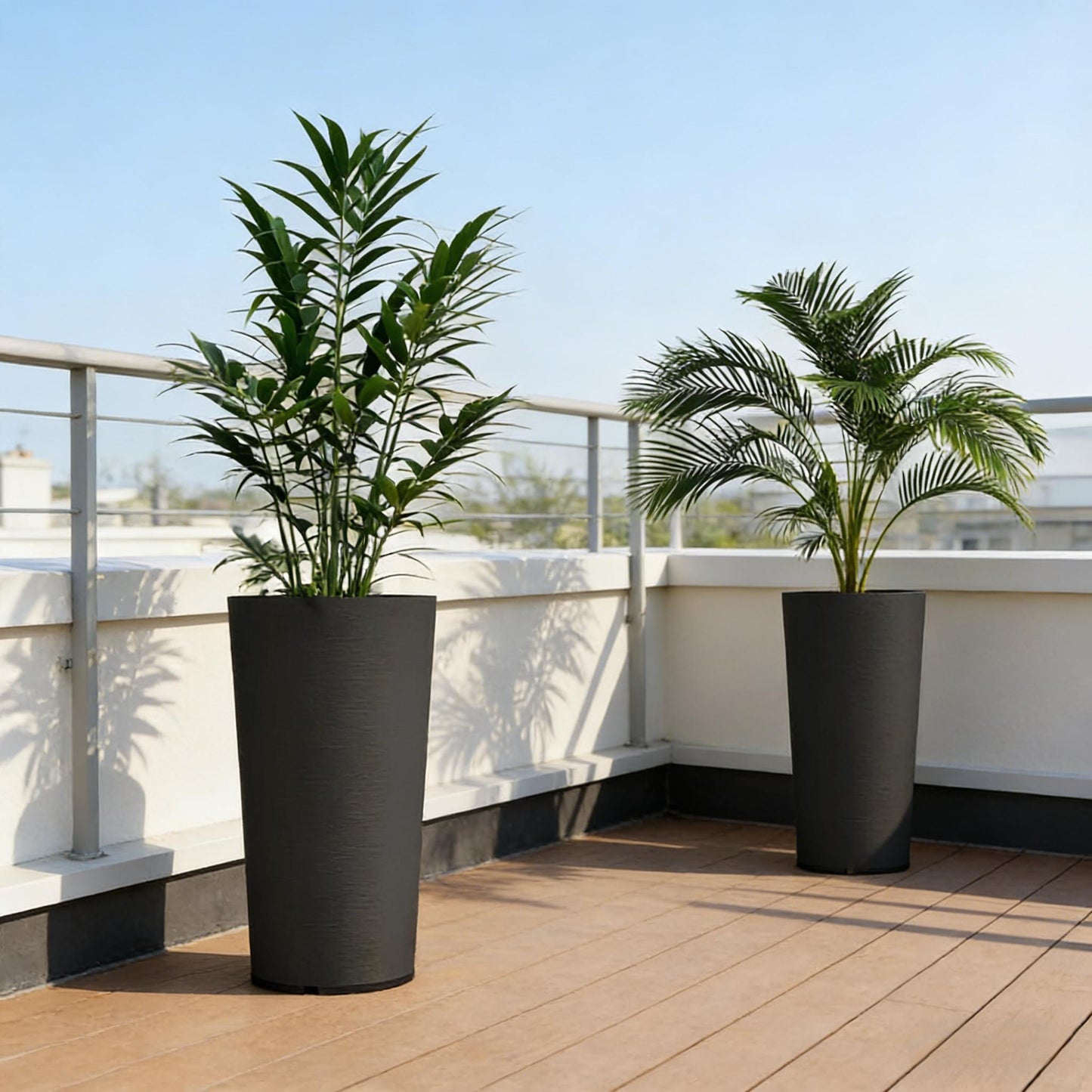 Set of 2 stackable large flower pots in black with tall leafy plants on a balcony railing on Tampa Home & Garden Store