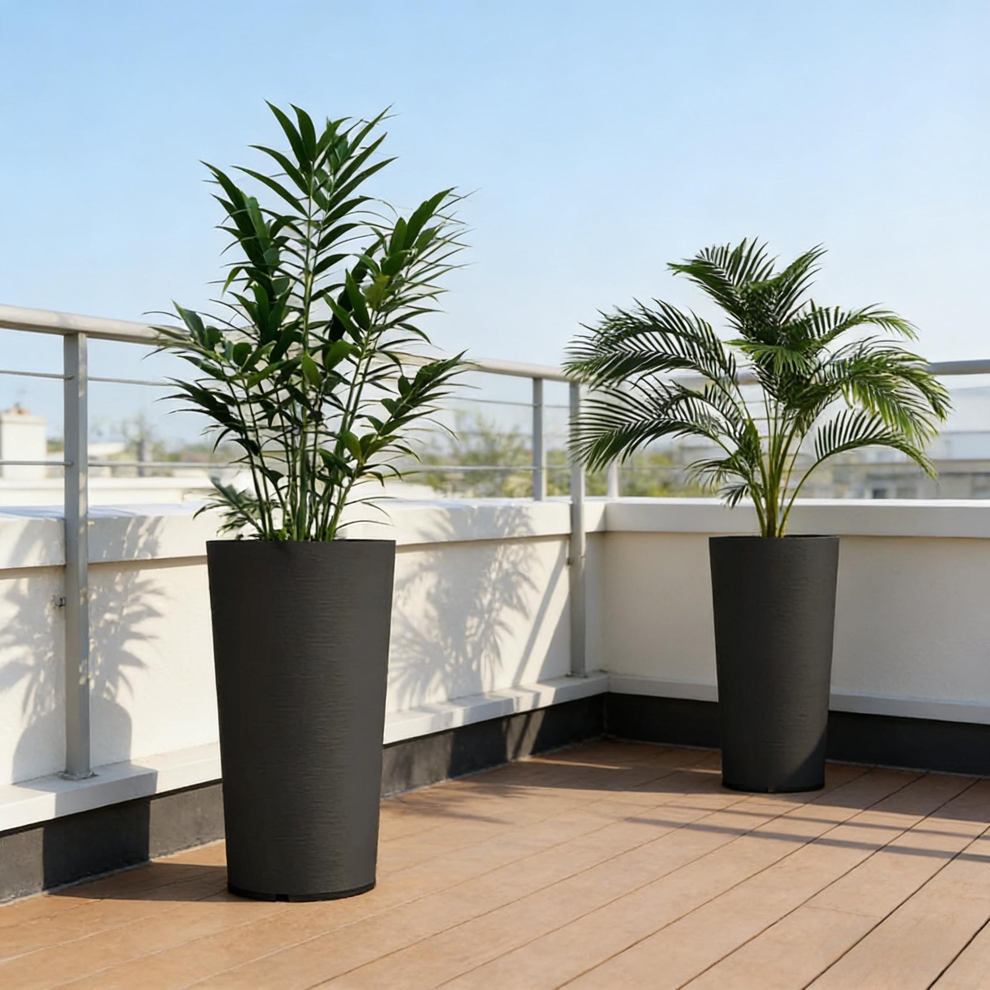 Set of 2 stackable large flower pots in black with tall leafy plants on a balcony railing on Tampa Home & Garden Store