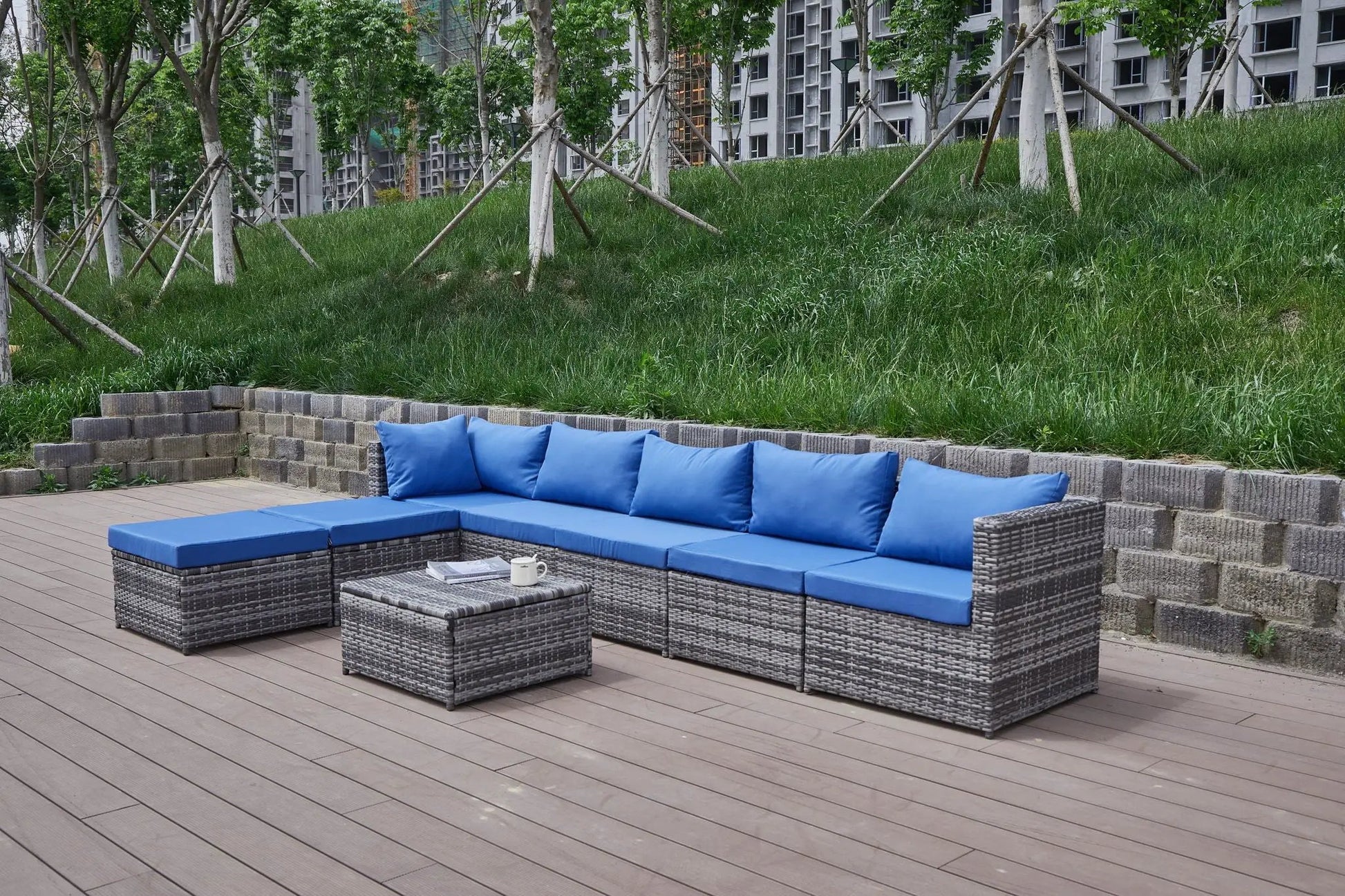 Patio sofa with blue cushions on a wicker sectional with ottomans by Unique Piece Furniture on Tampa Home & Garden Store