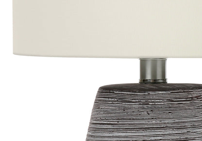 Contemporary table lamp with cream fabric shade, metal neck, and dark distressed wood base on Tampa Home & Garden Store