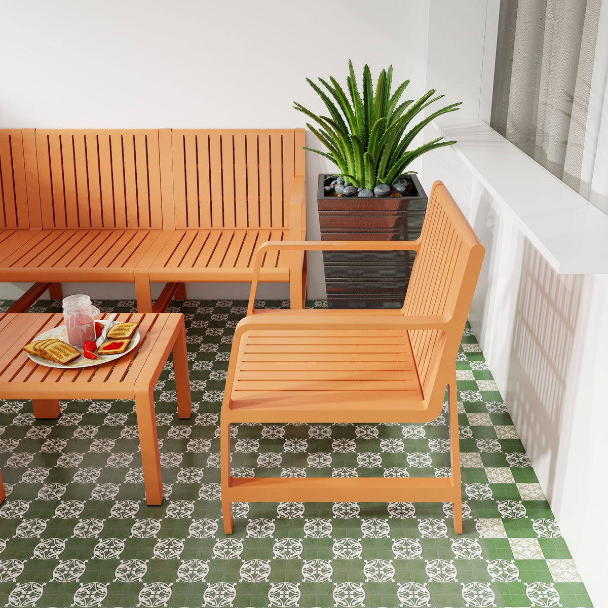 Orange 2-piece slatted metal outdoor patio set on balcony beside a green plant in a square pot on Tampa Home & Garden Store