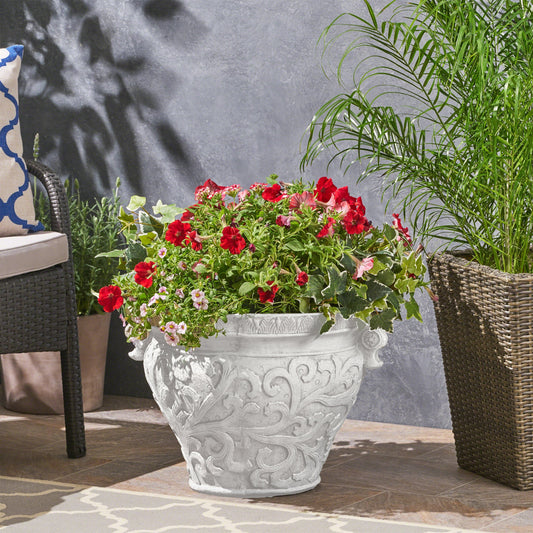 Largo planter by HouseOfZazla in gray stone finish with ornate carvings and red geraniums on Tampa Home & Garden Store