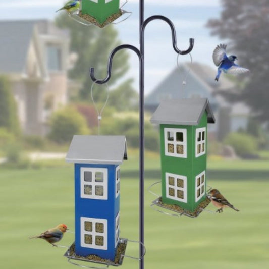 Blue and green iron bird feeders shaped like houses with seed trays on a garden post on Tampa Home & Garden Store